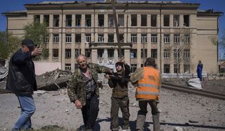 CAPTION CORRECTS THE LOCATION -People clean an area after Russian airstrike in Kostyantynivka, Donetsk region, Ukraine, Saturday, May 7, 2022. (AP Photo/Evgeniy Maloletka)