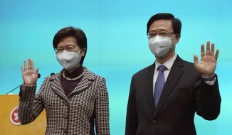 Chief Executive-elect John Lee, right, and incumbent Chief Executive Carrie Lam attend a press conference in Hong Kong, Monday, May 9, 2022. Lee was elected as the city’s next leader on Sunday in a vote cast by a largely pro-Beijing committee. (AP Photo/Kin Cheung)