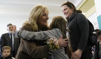 First lady Jill Biden gets a hug from Ukrainian refugee Yulie Kutocha, 7, as her mother Victorie Kutocha, watches at right, during a visit to a city-run refugee center in Kosice, Slovakia, Sunday, May 8, 2022. The center is a place for Ukrainian refugees to rest and prepare for onward travel. Biden will then travel to the Slovak border with Ukraine to meet with refugees. (AP Photo/Susan Walsh, Pool)