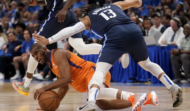 Phoenix Suns guard Chris Paul attempts to pass the ball as Dallas Mavericks&#x27; Jalen Brunson (13) attempts to avoid colliding with him in the second half of Game 4 of an NBA basketball second-round playoff series, Sunday, May 8, 2022, in Dallas. (AP Photo/Tony Gutierrez) **FILE**