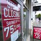 Passers-by walk past a business storefront with store closing and sale signs in Dedham, Mass.  (AP Photo/Steven Senne)