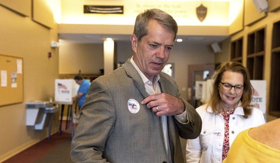 Jim Pillen receives a sticker after voting at his polling place, Columbus Berean Church, in Columbus, Neb., on Tuesday, May 10, 2022. (Eileen T. Meslar/Omaha World-Herald via AP)