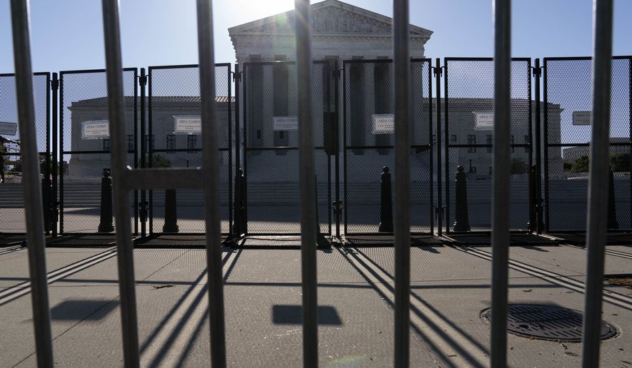 An anti-scaling fence is seen outside of the U.S. Supreme Court, Tuesday, May 10, 2022 in Washington. A draft opinion suggests the U.S. Supreme Court could be poised to overturn the landmark 1973 Roe v. Wade case that legalized abortion nationwide, according to a Politico report. (AP Photo/Jose Luis Magana)