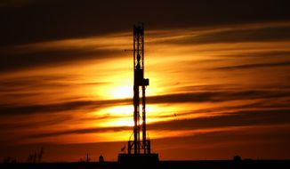 FILE - An oil drilling rig is pictured at sunset, Monday, March 7, 2022, in El Reno, Okla. A federal appeals court in New Orleans hears arguments Tuesday, May 10, 2022, about whether President Joe Biden legally suspended new oil and gas lease sales because of climate change worries. (AP Photo/Sue Ogrocki, File)