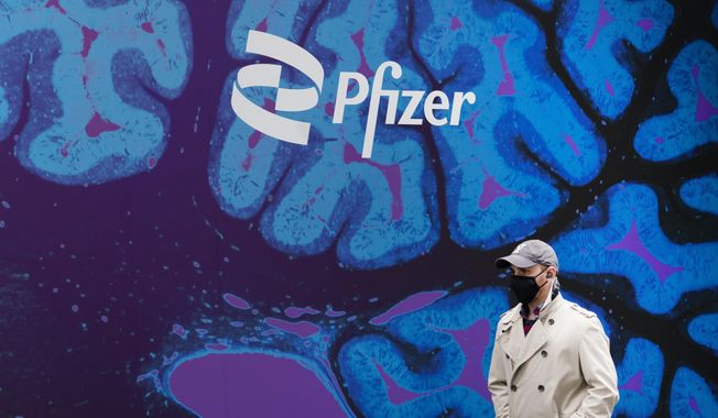 A man walks by Pfizer headquarters, Friday, Feb. 5, 2021 in New York. Pfizer is spending more than $11 billion to buy the remaining portion of migraine treatment maker Biohaven Pharmaceuticals it does not already own. The New York drugmaker said Tuesday, May 10, 2022,  it will pay $148.50 in cash for each share of Biohaven, which makes Nurtec ODT for treating and preventing migraines and has another nasal spray under development. (AP Photo/Mark Lennihan, File)