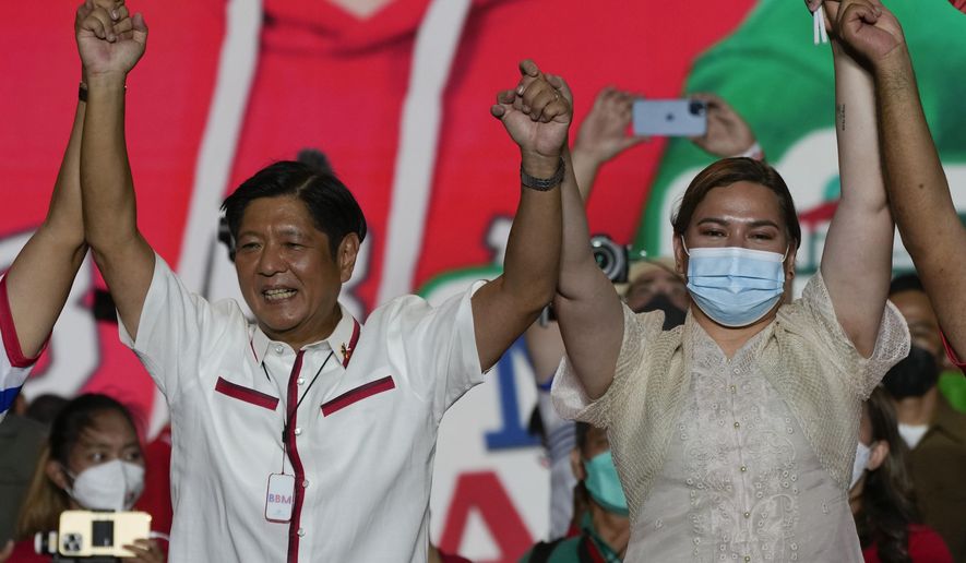Presidential candidate Ferdinand Marcos Jr., the son of the late dictator, left, raises arms with running mate Davao City Mayor Sara Duterte, the daughter of the current president, during their last campaign rally Saturday, May 7, 2022, in Paranaque city, Philippines. Marcos Jr. and Duterte are the new leaders of the Philippines, an alliance that ushers in six years of governance that has some human rights activists concerned about the course their country may take with the pair in power. (AP Photo/Aaron Favila, File)