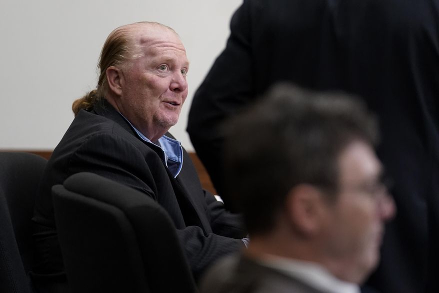 Celebrity chef Mario Batali, left, speaks with his defense attorney Anthony Fuller, arms only at right, as prosecutor Ian Polumbaum is seated, below right, during a break in proceedings on the first day of Batali&#x27;s pandemic-delayed trial, at Boston Municipal Court, Monday, May 9, 2022, in Boston. Batali pleaded not guilty to a charge of indecent assault and battery in 2019, stemming from accusations that he forcibly kissed and groped a woman after taking a selfie with her at a Boston restaurant in 2017. (AP Photo/Steven Senne, Pool)
