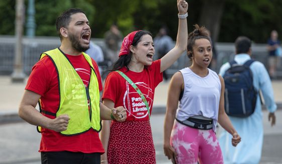 Elias Alicea, left, and Astrin Alicea, center, chant during an abortion rights protest led by the Party for Socialism and Liberation in front of the Supreme Court of the United States in Washington on Wednesday, May 11, 2022. (AP Photo/Amanda Andrade-Rhoades)