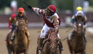 Sonny Leon celebrates after riding Rich Strike past the finish line to win the 148th running of the Kentucky Derby horse race at Churchill Downs Saturday, May 7, 2022, in Louisville, Ky. (AP Photo/Charlie Neibergall)