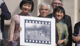 Pulitzer Prize-winning photographer Nick Ut, center, flanked by Kim Phuc, left, holds the&amp;quot; Napalm Girl&amp;quot;, his Pulitzer Prize winning photo as they wait to meet with Pope Francis during the weekly general audience in St. Peter&#39;s Square at The Vatican, Wednesday, May 11, 2022. Ut and UNESCO Ambassador Kim Phuc are in Italy to promote the photo exhibition &amp;quot;From Hell to Hollywood&amp;quot; resuming Ut&#39;s 51 years of work at the Associated Press, including the 1973 Pulitzer-winning photo of Kim Phuc fleeing her village after it was accidentally hit by napalm bombs dropped by South Vietnamese forces. (AP Photo/Gregorio Borgia)