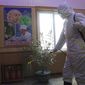 An official of the Hygienic and Anti-epidemic Center in Phyongchon District disinfect the corridor of a building in Pyongyang, North Korea, on Feb. 5, 2021. (AP Photo/Jon Chol Jin, File)