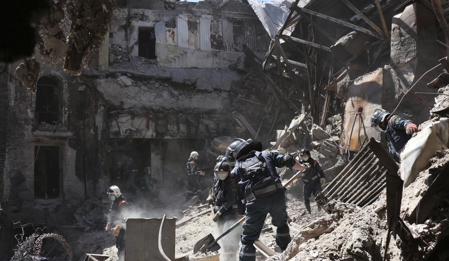 Donetsk People Republic Emergency Situations Ministry employees clear rubble at the side of the damaged Mariupol theater building during heavy fighting in Mariupol, in territory under the government of the Donetsk People&#39;s Republic, eastern Ukraine, Thursday, May 12, 2022. (AP Photo)
