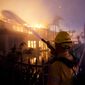 A firefighter works to put at a structure burning during a wildfire Wednesday, May 11, 2022, in Laguna Niguel, Calif. (AP Photo/Marcio J. Sanchez)