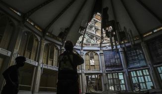 A member of the Cuban Red Cross takes pictures inside the Calvary Baptist Church, damaged by an explosion that devastated Havana&#39;s Hotel Saratoga, in Old Havana, Cuba, Wednesday, May 11, 2022. Church officials say that fortunately, none of the people inside were hurt in the May 6 explosion. (AP Photo/Ramon Espinosa)