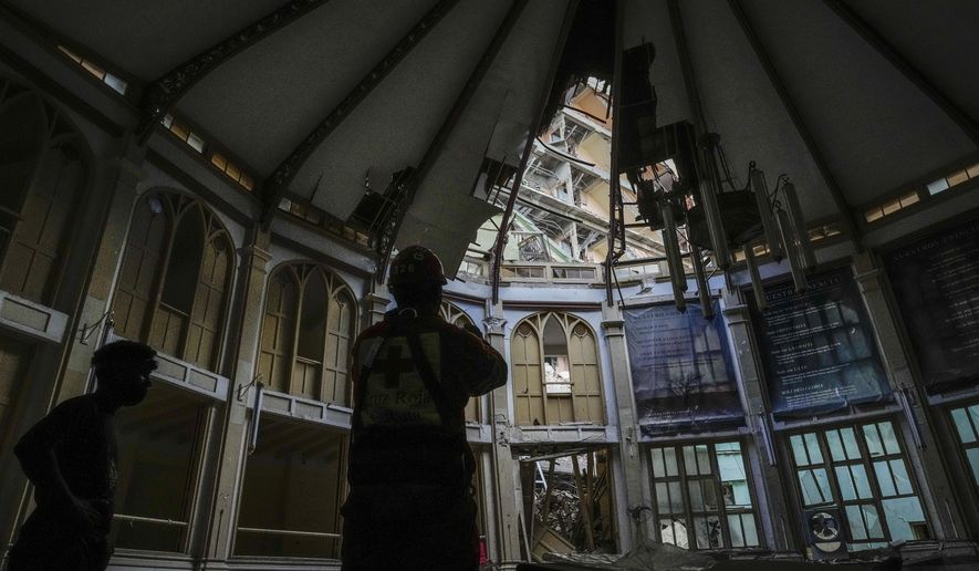 A member of the Cuban Red Cross takes pictures inside the Calvary Baptist Church, damaged by an explosion that devastated Havana&#x27;s Hotel Saratoga, in Old Havana, Cuba, Wednesday, May 11, 2022. Church officials say that fortunately, none of the people inside were hurt in the May 6 explosion. (AP Photo/Ramon Espinosa)