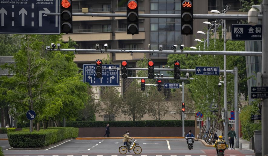 A man wearing a face mask rides a bicycle across a quiet intersection in the central business district during the morning rush hour as most workers in the area have been ordered to work from home in Beijing, Thursday, May 12, 2022. China&#39;s leaders are struggling to reverse a deepening economic slump while keeping a &amp;quot;zero-COVID&amp;quot; strategy that has shut down Shanghai and other cities. (AP Photo/Mark Schiefelbein)