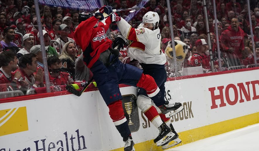 Washington Capitals left wing Marcus Johansson, left, and Florida Panthers defenseman Ben Chiarot collide along the boards during the first period of Game 6 in the first round of the NHL Stanley Cup hockey playoffs, Friday, May 13, 2022, in Washington. (AP Photo/Alex Brandon)