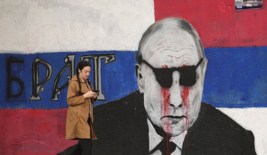 A woman passes by a mural depicting the Russian President Vladimir Putin that reads: &#x27;&#x27;Brother&#x27;&#x27; vandalized with paint, in Belgrade, Serbia, Saturday, May 7, 2022. Despite having to pay a big price Serbia for not introducing sanctions to Russia, Serbia will not do it , Serbian President Vucic said, but despite that the country will stay on its path toward the EU. (AP Photo/Darko Vojinovic)