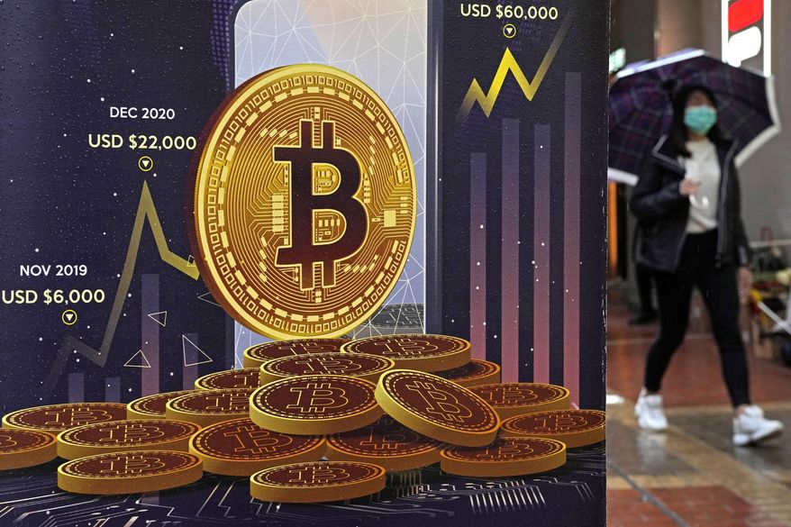 FILE - An advertisement for Bitcoin cryptocurrency is displayed on a street in Hong Kong, Thursday, Feb. 17, 2022. It’s been a wild week in crypto, even by crypto standards. Bitcoin tumbled, stablecoins were anything but stable and one of the crypto industry’s highest-profile companies lost a third of its market value. (AP Photo/Kin Cheung, File)