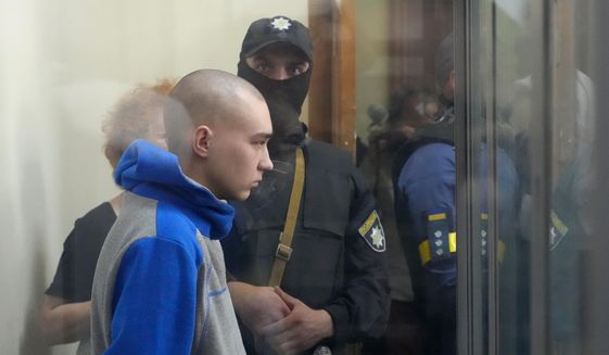 Russian army Sgt. Vadim Shishimarin, 21, is seen behind glass during a court hearing in Kyiv, Ukraine, Friday, May 13, 2022. The trial of a Russian soldier accused of killing a Ukrainian civilian opened Friday, the first war crimes trial since Moscow&#39;s invasion of its neighbor. (AP Photo/Efrem Lukatsky)