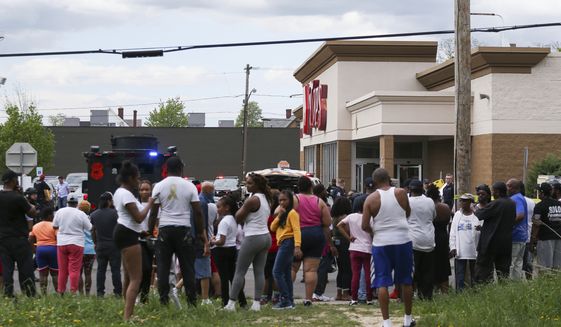 A crowd gathers as police investigate after a shooting at a supermarket on Saturday, May 14, 2022, in Buffalo, N.Y. Multiple people were shot  at the Tops Friendly Market.  Police have notified the public that the alleged shooter was in custody. (AP Photo/Joshua Bessex)