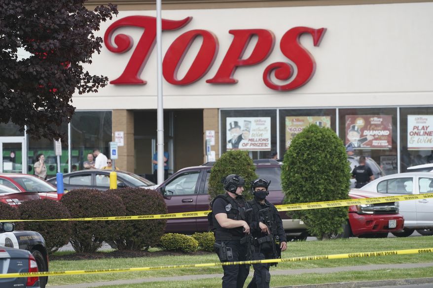 Police secure an area around a supermarket where several people were killed in a shooting, Saturday, May 14, 2022 in Buffalo, N.Y. Officials said the gunman entered the supermarket with a rifle and opened fire. Investigators believe the man may have been livestreaming the shooting and were looking into whether he had posted a manifesto online (Derek Gee/The Buffalo News via AP)