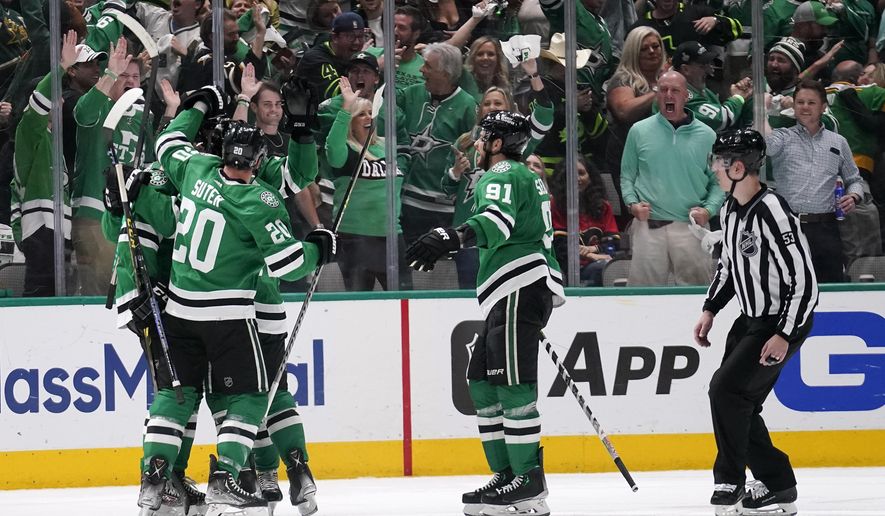 Dallas Stars players celebrate a goal by Miro Heiskanen during the second period of Game 6 of an NHL hockey Stanley Cup first-round playoff series against the Calgary Flames, Friday, May 13, 2022, in Dallas. (AP Photo/Tony Gutierrez)