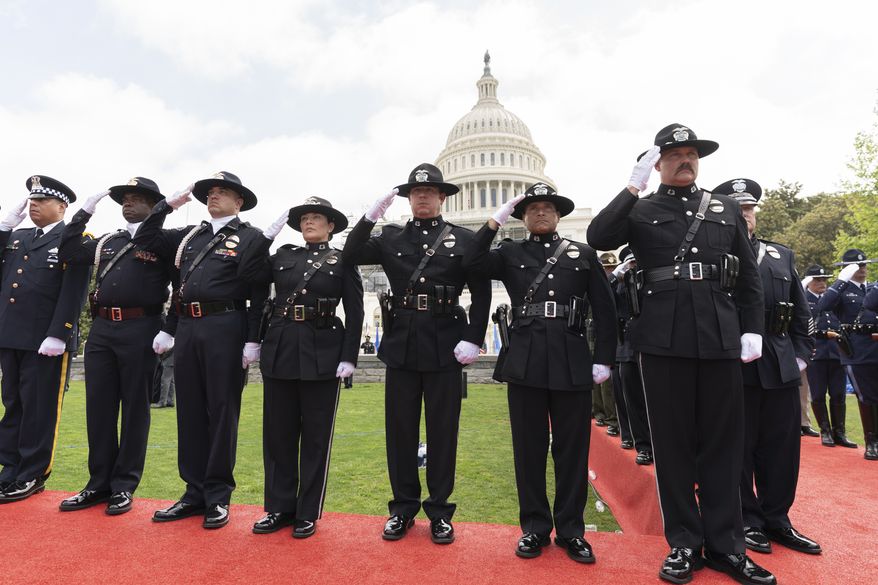Police honor guards salute as the Star Spangled is played during the National Peace Officers&#39; Memorial Service on the West Front of the Capitol in Washington, Sunday, May 15, 2022, honoring the law enforcement officers who lost their lives in the line of duty in 2021. (AP Photo/Manuel Balce Ceneta)