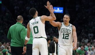 Boston Celtics forward Jayson Tatum (0) celebrates with forward Grant Williams (12) as the Celtics lead the Milwaukee Bucks during the second half of Game 7 of an NBA basketball Eastern Conference semifinals playoff series, Sunday, May 15, 2022, in Boston. (AP Photo/Steven Senne)