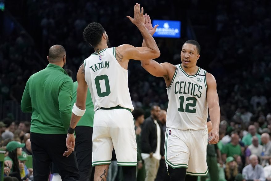 Boston Celtics forward Jayson Tatum (0) celebrates with forward Grant Williams (12) as the Celtics lead the Milwaukee Bucks during the second half of Game 7 of an NBA basketball Eastern Conference semifinals playoff series, Sunday, May 15, 2022, in Boston. (AP Photo/Steven Senne)