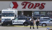 Police walk outside the Tops grocery store on Sunday, May 15, 2022, in Buffalo, N.Y. A white 18-year-old wearing military gear and livestreaming with a helmet camera opened fire with a rifle at the supermarket, killing and wounding people in what authorities described as racially motivated violent extremism. (AP Photo/Joshua Bessex)