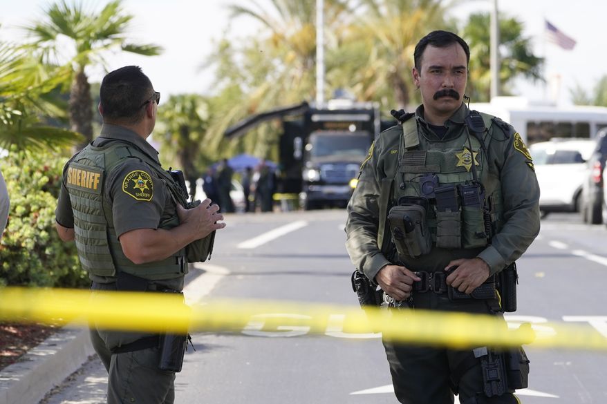 Orange County Sheriff's deputies guard the parking lot of Geneva Presbyterian Church in Laguna Woods, Calif., Sunday, May 15, 2022, after a fatal shooting. (AP Photo/Damian Dovarganes)