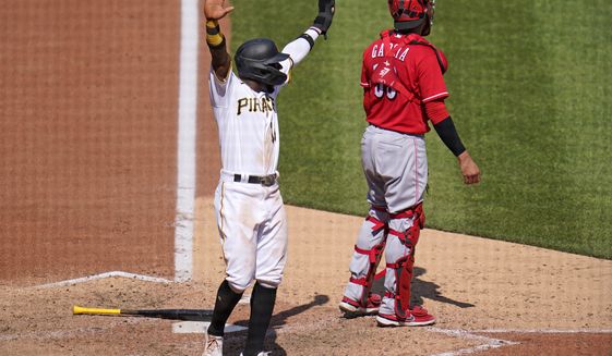 Pittsburgh Pirates&#39; Rodolfo Castro, left, celebrates as Ke&#39;Bryan Hayes beats out a fielder&#39;s choice allowing Castro to score from third during the eighth inning of a baseball game against the Cincinnati Reds in Pittsburgh, Sunday, May 15, 2022. The Pirates won 1-0. (AP Photo/Gene J. Puskar)