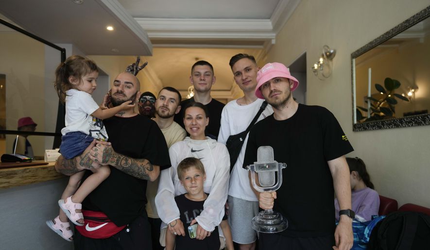 Kalush Orchestra of Ukraine pose with their relatives and the trophy before leaving Universo Hotel after winning the Grand Final of the Eurovision Song Contest, in Turin, Italy, Sunday, May 15, 2022. (AP Photo/Luca Bruno)