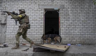 A Ukrainian serviceman patrols during a reconnaissance mission in a recently retaken village on the outskirts of Kharkiv, east Ukraine, Saturday, May 14, 2022. (AP Photo/Mstyslav Chernov)