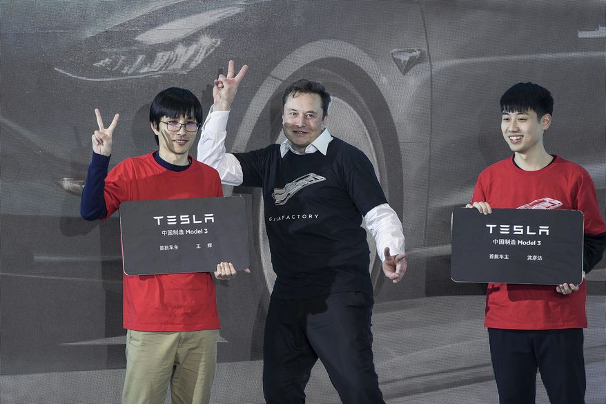 FILE - In this photo released by China&#39;s Xinhua News Agency, Tesla CEO Elon Musk, center, poses with Tesla owners at a delivery ceremony for the first Tesla Model 3 cars made at Tesla&#39;s Shanghai factory in Shanghai on Jan. 7, 2020. Musk’s ties to China through his role as electric car brand Tesla’s biggest shareholder could add complexity to his bid to buy Twitter. (Ding Ting/Xinhua via AP, File)