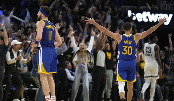 Golden State Warriors guard Stephen Curry (30) celebrates a 3-pointer by Klay Thompson, left, against the Memphis Grizzlies during the second half of Game 6 of an NBA basketball Western Conference playoff semifinal in San Francisco, Friday, May 13, 2022. The Warriors won 110-96 and advanced to the conference finals. (AP Photo/Tony Avelar) ** FILE**