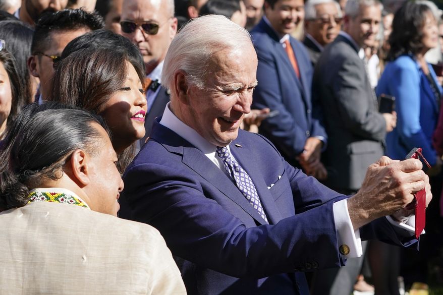 President Joe Biden takes a selfie with guests in the Rose Garden of the White House in Washington, Tuesday, May 17, 2022, during a reception to celebrate Asian American, Native Hawaiian, and Pacific Islander Heritage Month. (AP Photo/Susan Walsh)