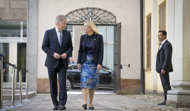 Finish President Sauli Niinisto, left, is received by Swedish Prime Minister Magdalena Andersson at the Adelcrantzska house in Stockholm, Sweden, Tuesday May 17, 2022. (Anders Wiklund/TT News Agency via AP)