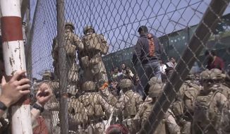 This image from a video released by the Department of Defense shows U.S. Marines at Abbey Gate before a suicide bomber struck outside Hamid Karzai International Airport on Aug. 26, 2021, in Kabul Afghanistan. A new report says decisions by Presidents Donald Trump and Joe Biden to pull all U.S. troops out of Afghanistan were the key factors in the collapse of that nation&#39;s military, leading to the Taliban takeover last year. (Department of Defense via AP, File)