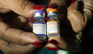 A nurse holds a vial of the Pfizer COVID-19 vaccine for children ages 5 to 11, right, and a vial of the vaccine for adults, which has a different colored label, at a vaccination station in Jackson, Miss., Tuesday, Feb. 8, 2022. U.S. regulators authorized a COVID-19 booster shot for healthy 5- to 11-year-olds on Tuesday, May 17, 2022, hoping an extra vaccine dose will enhance their protection as infections once again are on the rise. (AP Photo/Rogelio V. Solis) **FILE**