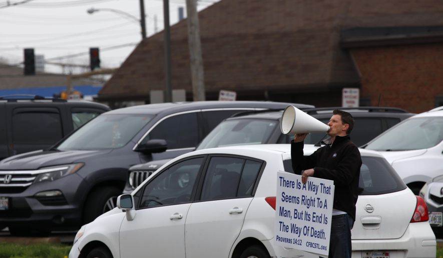 A pastor uses a megaphone to implore women not to get abortions on Tuesday, April 12, 2022, outside the Hope Clinic for Women in Granite City, Ill. &amp;quot;Don&#39;t murder your baby!&amp;quot; he shouted. The pastor, whose church is across the state line in the St. Louis area, declined to give his name but said he stands outside the clinic and does this often. More women from Missouri and states much farther away are coming to Illinois for abortions, as more states restrict that kind of care. (AP Photo/Martha Irvine)