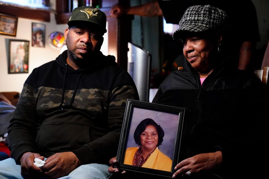 Wayne Jones, left, looks on as his aunt JoAnn Daniels, holds a photograph of his mother Celestine Chaney, who was killed in Saturday&#39;s shooting at a supermarket, during an interview with The Associated Press in Buffalo, N.Y., Monday, May 16, 2022. (AP Photo/Matt Rourke)