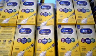 Infant formula is stacked on a table during a baby formula drive to help with the shortage May 14, 2022, in Houston.  President Joe Biden has invoked the Defense Production Act to speed production of infant formula and has authorized flights to import supply from overseas. (AP Photo/David J. Phillip, File)