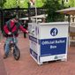 A voter drops off a ballot at a box in Pioneer Courthouse Square in Portland, Ore., Tuesday, May, 17, 2022. The state is holding its primary elections. (AP Photo/Gillian Flaccus)