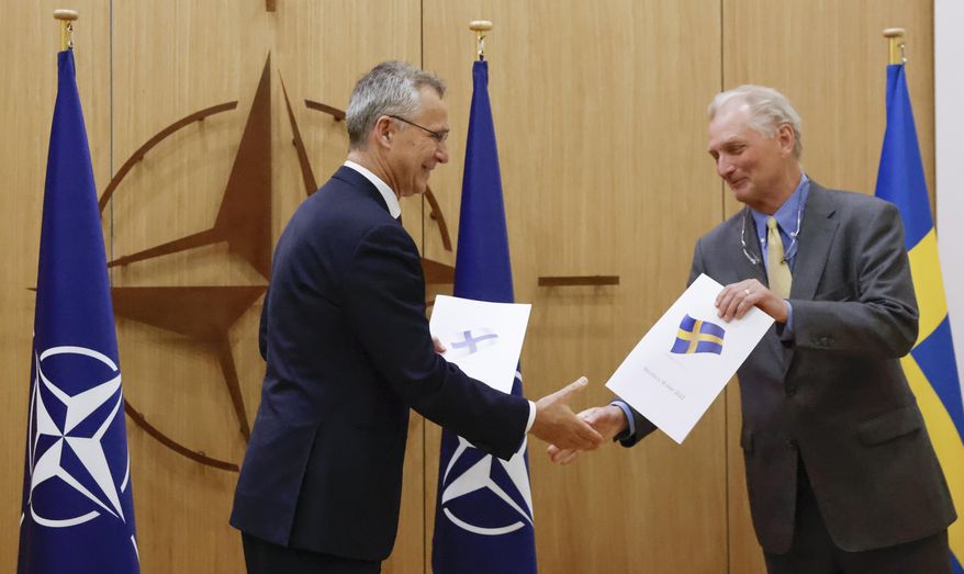 NATO Secretary-General Jens Stoltenberg and Sweden&#39;s Ambassador to NATO Axel Wernhoff shake hands during a ceremony to mark Sweden&#39;s and Finland&#39;s application for membership in Brussels, Belgium, Wednesday May 18, 2022. Stoltenberg said that the military alliance stands ready to seize a historic moment and move quickly on allowing Finland and Sweden to join its ranks, after the two countries submitted their membership requests. (Johanna Geron/Pool via AP)