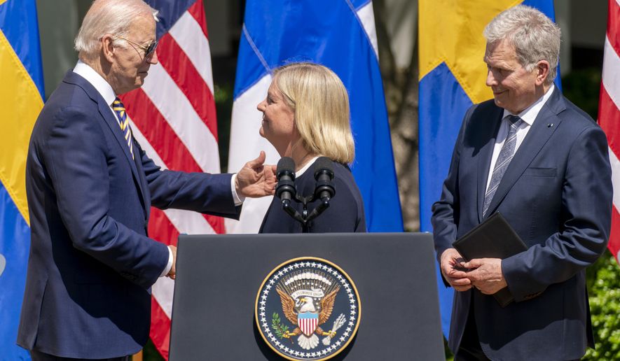 President Joe Biden, accompanied by Finnish President Sauli Niinisto, right, hugs Swedish Prime Minister Magdalena, center, after she speaks during an event in the Rose Garden of the White House in Washington, Thursday, May 19, 2022. (AP Photo/Andrew Harnik)
