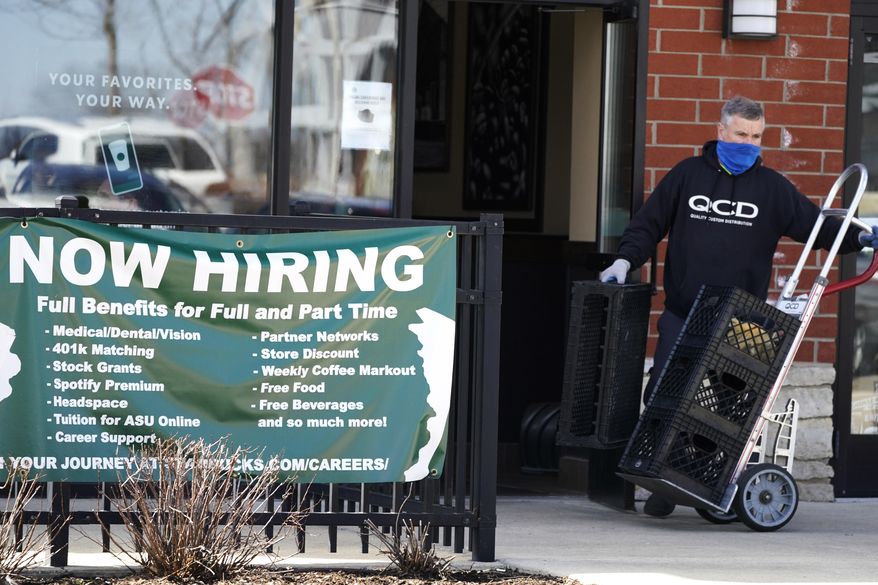 A hiring sign is displayed outside of a Starbucks in Schaumburg, Ill., Friday, April 1, 2022. The number of Americans applying for jobless aid ticked up slightly last week, but the total number of Americans collecting benefits remained at its lowest level in more than five decades. Applications for unemployment benefits rose by 1,000 to 203,000 for the week ending May 7, the Labor Department reported Thursday, May 12. (AP Photo/Nam Y. Huh)