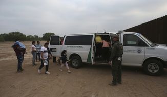 Migrants who had crossed the Rio Grande river into the U.S. are taken away by U.S. Border Patrol agents in Eagle Pass, Texas, Friday, May 20, 2022. The Eagle Pass area has become increasingly a popular crossing corridor for migrants, especially those from outside Mexico and Central America, under Title 42 authority, which expels migrants without a chance to seek asylum on grounds of preventing the spread of COVID-19. A judge was expected to rule on a bid by Louisiana and 23 other states to keep Title 42 in effect before the Biden administration was to end it Monday. (AP Photo/Dario Lopez-Mills)