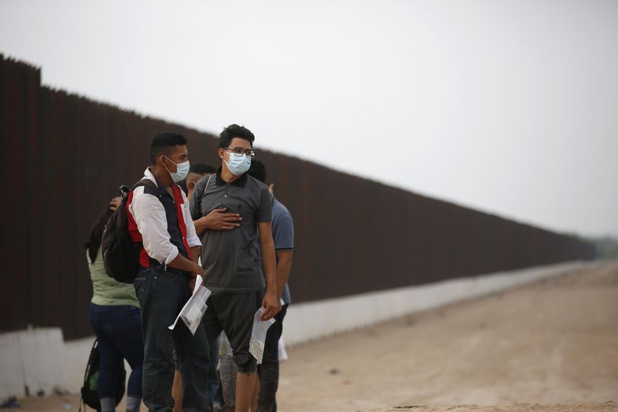 Migrants who had crossed the Rio Grande river into the U.S. wait to be processed by U.S. Border Patrol agents in Eagle Pass, Texas, Friday, May 20, 2022. As U.S. officials anxiously waited, many of the migrants crossing the border from Mexico on Friday were oblivious to a pending momentous court ruling on whether to maintain pandemic-related powers that deny a chance to seek asylum on grounds of preventing the spread of COVID-19. (AP Photo/Dario Lopez-Mills)